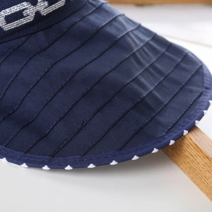 Close-up of visor stitching details and polka dot piping on foldable sun hat