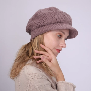 Close-up of knit newsboy hat showing textured geometric pattern and soft pink yarn fabric
