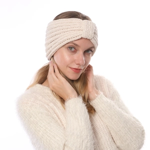 Dettaglio di una fascia per capelli in maglia di ciniglia beige con nodo a incrocio