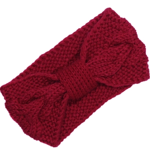 Detail of wine red knitted headband featuring a warm twist bow and soft knit texture