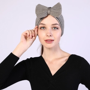 Detail of grey knitted bow headband featuring soft wool texture and warm thick weave