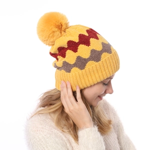 Nahaufnahme der Winter-Strickmütze mit gelbem Bommel und gewelltem Strickmuster