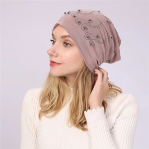Detail of mauve cotton beanie featuring elegant pearl and rhinestone spiral embroidery