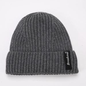 Detail of grey rib-knit beanie showing thick wool texture and Breakout woven label