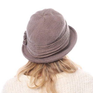 Detailed close-up of a mauve knit cloche hat featuring a handmade floral accent
