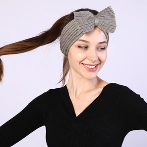 Detail of grey knitted bow headband showing the soft texture and thick crochet pattern