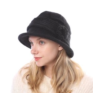 Close-up of black knit cloche hat with floral detail and warm faux rabbit fur texture