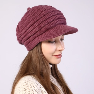 Detail view of purple knit newsboy cap with thick ribbed texture and vintage short brim