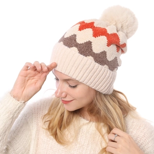 Detailaufnahme der Wintermütze mit Wellenmuster und flauschigem Kunstpelz-Bommel
