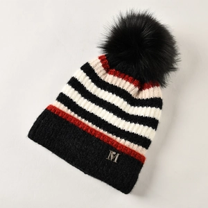Detailaufnahme der gestreiften Strickmütze mit Pelzbommel und silbernem M-Logo