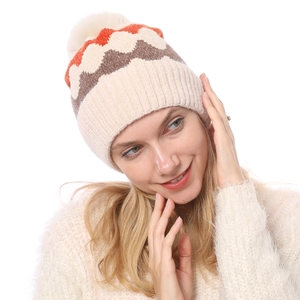 Detaillierte Strickstruktur und beigefarbener Bommel an warmer Chenille-Wintermütze