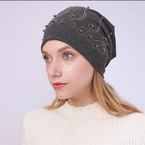 Detail of dark grey cotton beanie featuring silver beads and rhinestone wave patterns