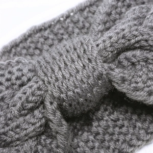 Macro shot of grey cable knit headband texture and central cross knot detail