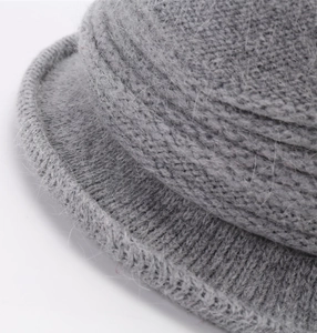 Macro shot of grey rabbit fur blend knit hat showing thick plush texture and soft yarn detail