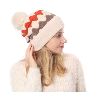 Detailaufnahme der dicken Chenille-Strickmütze mit Wellenmuster und Kunstpelz-Bommel