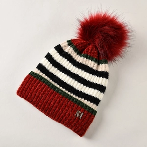 Detailaufnahme der Winterstrickmütze mit bunten Streifen, Bommel und Metall-M-Verzierung