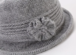 Detailed close-up of grey knitted wool flower on a thick winter bucket hat for women