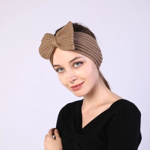 Detail of khaki knitted headband with large bow texture for autumn and winter wear