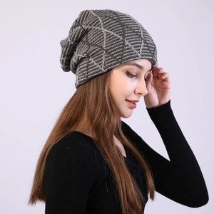 Detail view of slouchy beanie featuring a diamond grid knit pattern and mixed grey tones