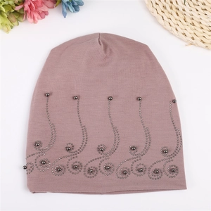Detail of mauve cotton beanie featuring elegant rhinestone scroll pattern and grey beads