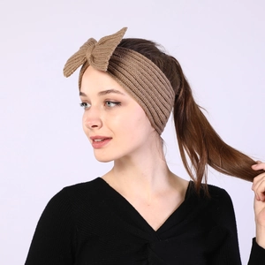 Close-up of brown knit headband for women featuring a large bow and thick wool texture