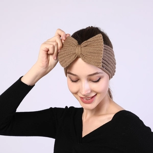 Close-up of khaki knitted bow headband showing thick yarn texture and elastic design