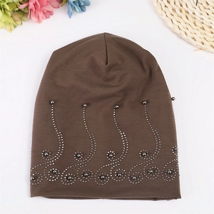 Detail of dark brown cotton beanie featuring intricate silver bead floral embroidery