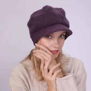 Detail of deep purple knit visor hat with geometric weave and ribbed brim on model