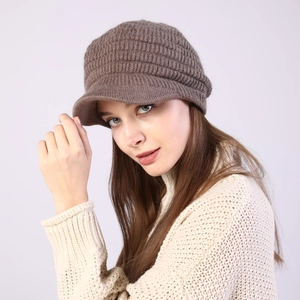 Close-up of the thick ribbed knit texture and visor detail on a brown winter beanie