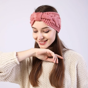 Detailed knit texture of a pink winter headband with a twisted knot design