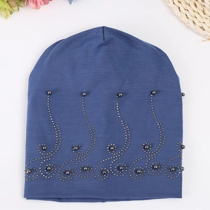 Close-up of dark blue cotton slouchy beanie with grey beadwork and scroll patterns