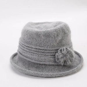 Detail of grey winter knit bucket hat showing faux rabbit fur texture and floral decor