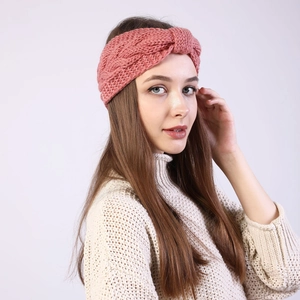 Detail of pink cable knit headband showing twist knot design and warm textured wool