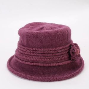 Detail of burgundy thick knit bucket hat showing faux fur texture and crochet flower