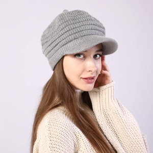 Close-up of light grey knit visor beanie with ribbed texture worn by a female model