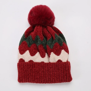 Detail der Strickmütze mit Wellenmuster und weichem Bommel für den Winter aus Chenille
