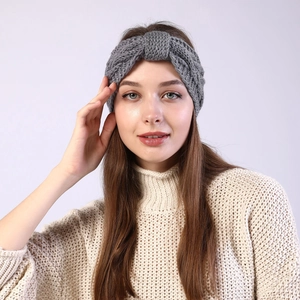 Detail of grey cable knit headband with twist knot design worn with cozy autumn sweater