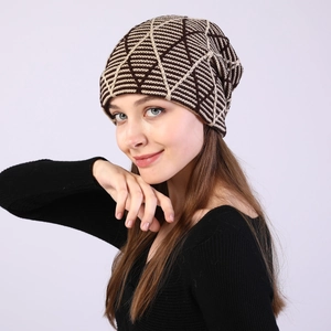 Close-up of knit beanie with brown geometric pattern worn by a model in soft studio lighting