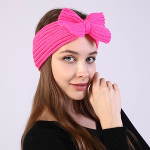 Bright pink knitted bow headband for women made of warm ribbed wool for winter