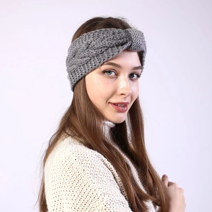 Close-up of a grey knitted twist headband for women featuring warm cable knit texture