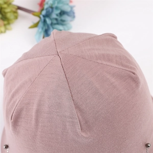Detailed top view of pink cotton beanie showing six-panel stitching and silver metal beads