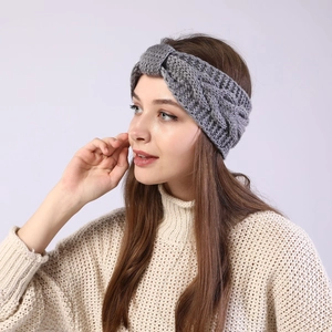 Detail of gray knitted headband featuring a classic twist knot and thick cable knit texture