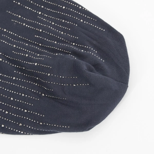 Close-up of charcoal gray cotton slouchy beanie featuring detailed silver rhinestone patterns