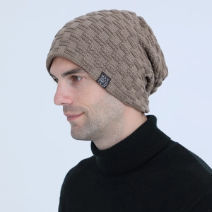 Detail of tan brown knit beanie with textured grid pattern and woven tiger label
