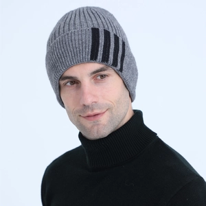 Detail of grey knitted beanie featuring three black stripes and thick wool texture
