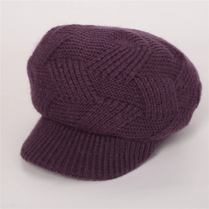 Macro detail of dark purple knit newsboy cap showing twill pattern and thick warm texture