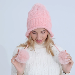 Dettaglio del cappello in maglia rosa con soffici pompon sulle orecchie e corona