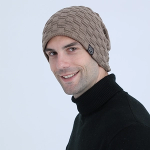 Close-up of khaki knit beanie featuring embossed texture and a round black logo patch