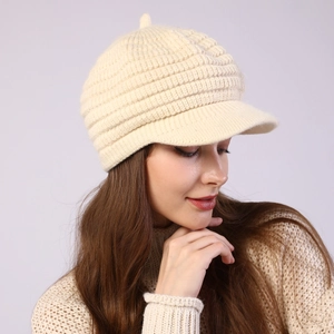 Close-up of cream knit visor beanie with striped texture and soft fleece lining