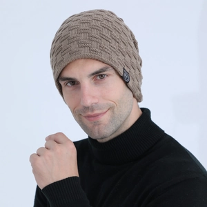 Detail of khaki waffle-knit men's beanie featuring a stitched round logo label